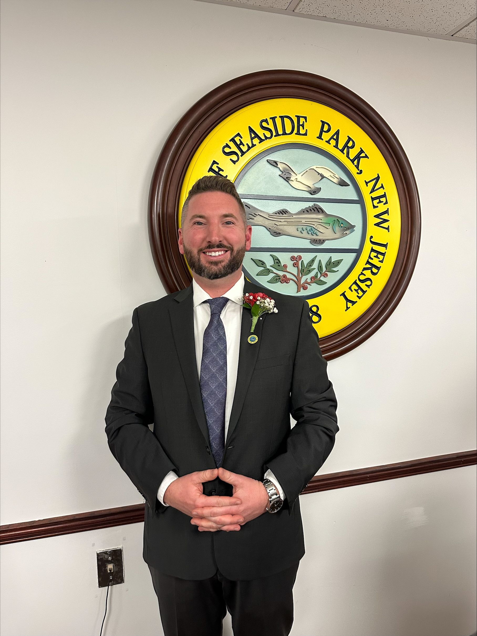 Council Member Toth standing in front of the Borough Seal